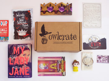 A closed OwlCrate subscription box surrounded by young adult books and related items.